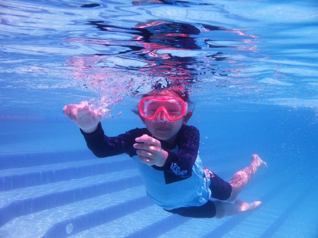 เด็กผู้หญิงดำน้ำอย่างสนุกสนาน